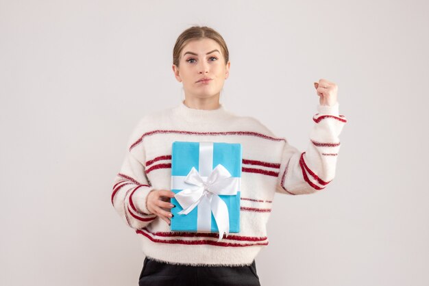 young female holding present on white