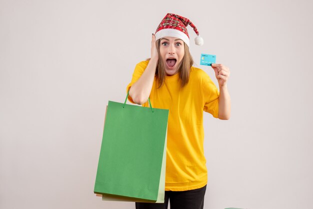 young female holding shopping packages and bank card on white