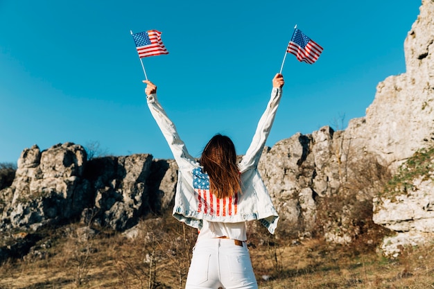 Free photo young female holding usa flags above head