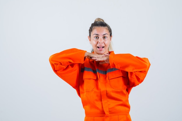 Free photo young female leaning her jaw on her hand in worker uniform and looking impatient , front view.