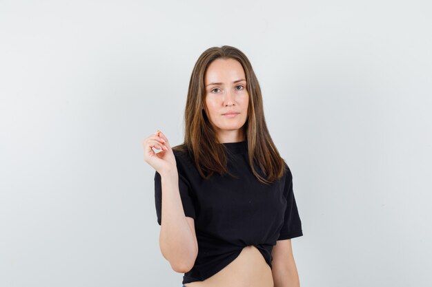 Young female looking at camera in black blouse and looking sensible