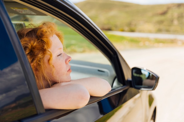 Young female looking out of car window