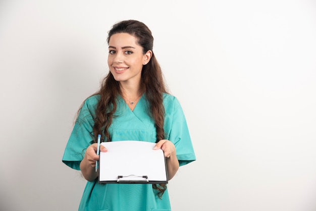 Young female medical employee holding medical records.