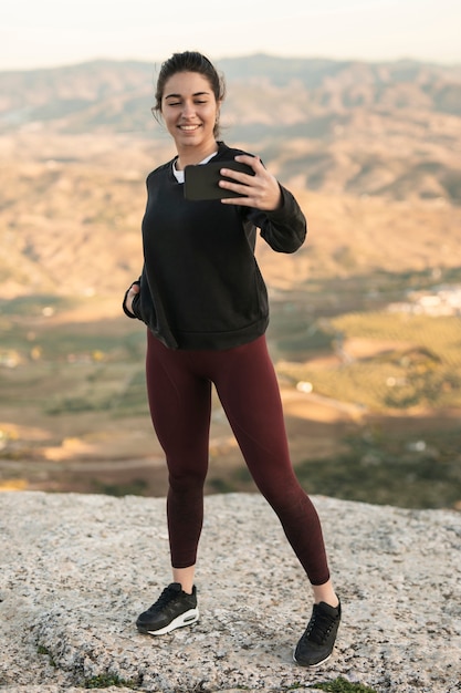 Young female on mountain taking selfie