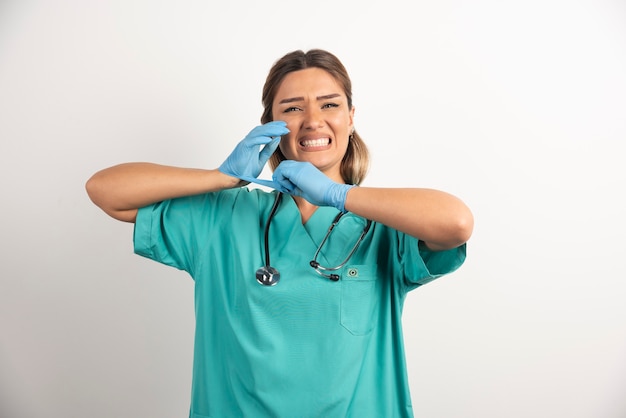 Young female nurse posing dressed in medical gown.