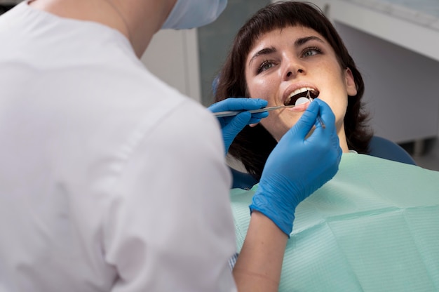 Free photo young female patient having dental procedure at the orthodontist