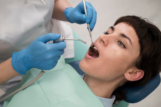 Free photo young female patient having dental procedure at the orthodontist