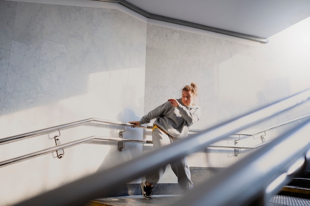 Young female performer dancing in an abandoned building on stairs