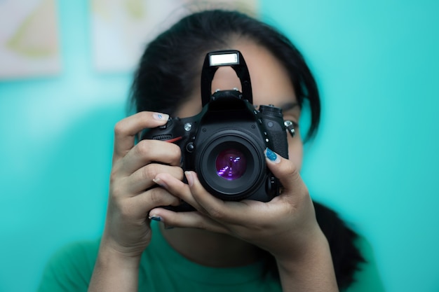 Free photo young female photographer taking a picture with a dslr camera