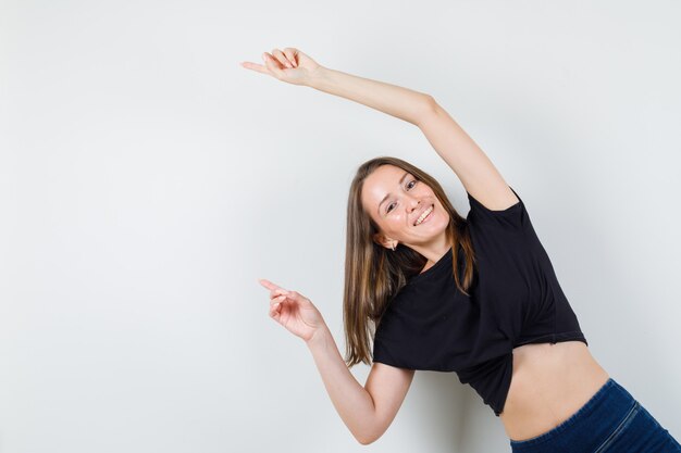 Young female posing while pointing away in black blouse