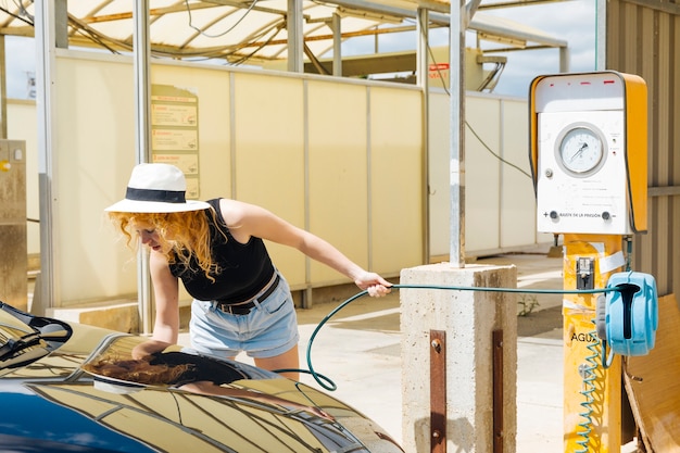 Free photo young female pumping car tires at petrol station