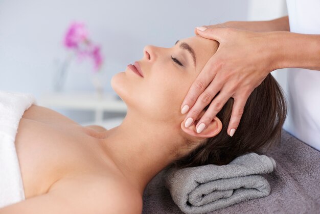 Young female receiving professional facial massage