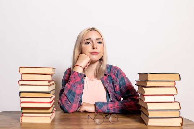 Free photo young female sitting with books on white