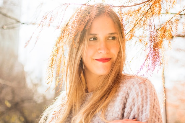 Free photo young female smiles aside on autumn surface