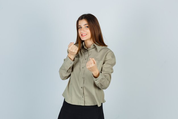 Young female standing in fight pose in shirt, skirt and looking merry