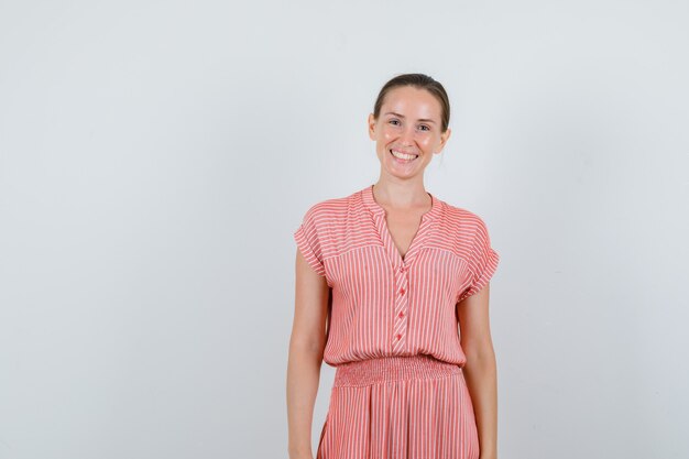 Young female in striped dress and looking happy. front view.