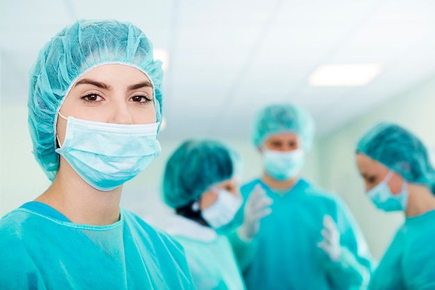 Free Photo young female surgeon with medical team in back before surgery