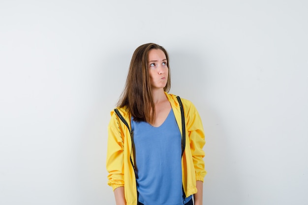 Free photo young female in t-shirt, jacket looking up and looking thoughtful, front view.