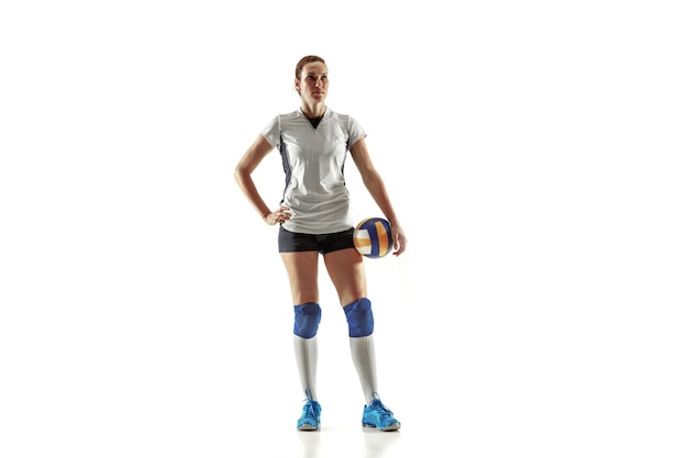 Free photo young female volleyball player isolated on white wall. woman in sport's equipment and shoes or sneakers training and practicing. concept of sport, healthy lifestyle, motion and movement.