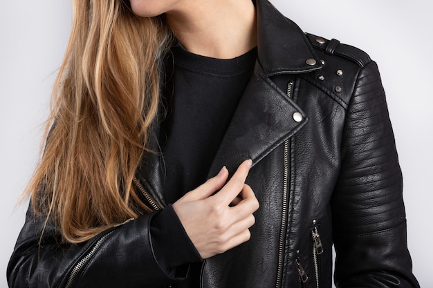 Free Photo young female wearing a jacket standing against a white wall