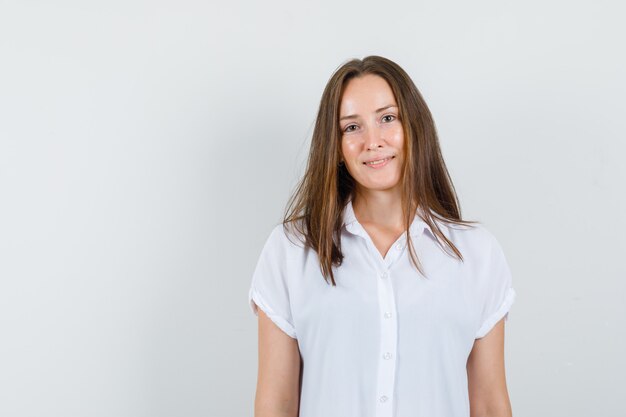 Young female in white blouse standing and looking calm