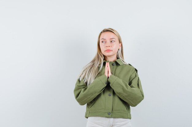 Young female wishing in green jacket,jeans , front view.