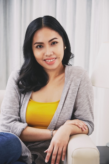 Young Filipino woman sitting on couch