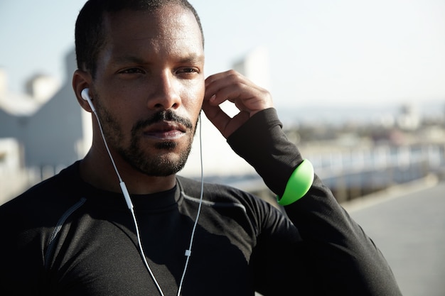 Young fit man at the beach listening to music