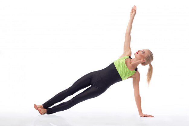 Young fitness female planking on the floor isolated on white