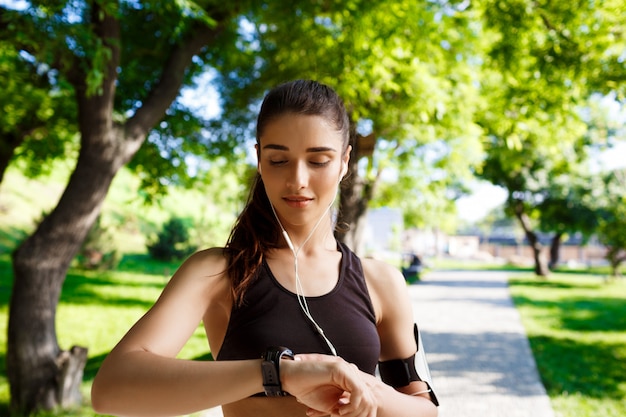 young fitness girl looking at watch