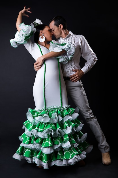 Free Photo young flamenco dancers in beautiful dress on black background.