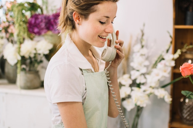 Young florist speaking on phone