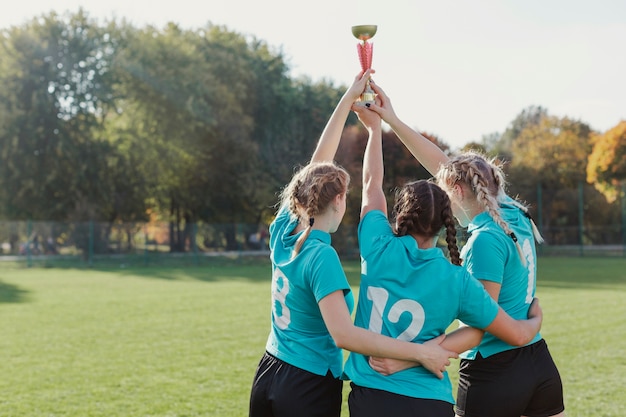 Young football players raising a trophy