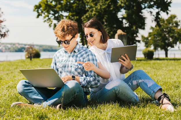 Young freelancers couple working in the park