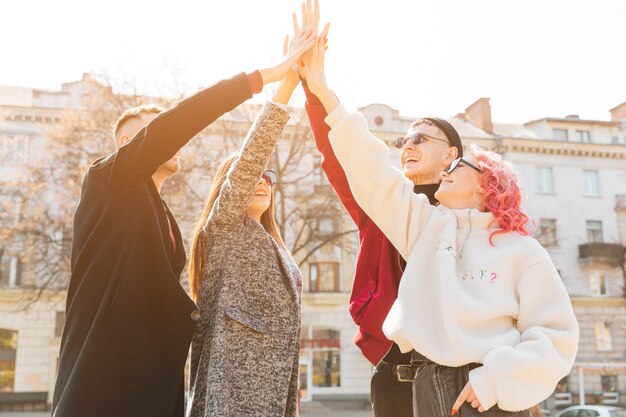 Young friend lifting stacked hands together