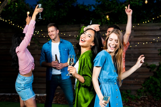 Young friends dancing together outdoors