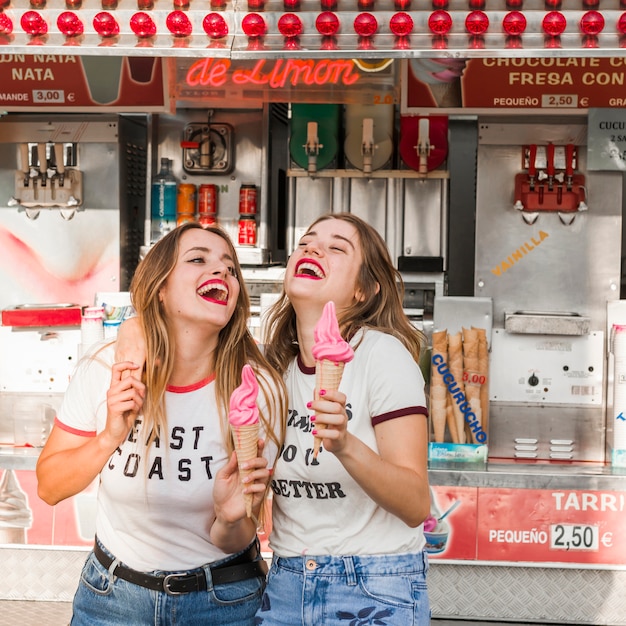 Free Photo young friends eating ice cream in the amusement park