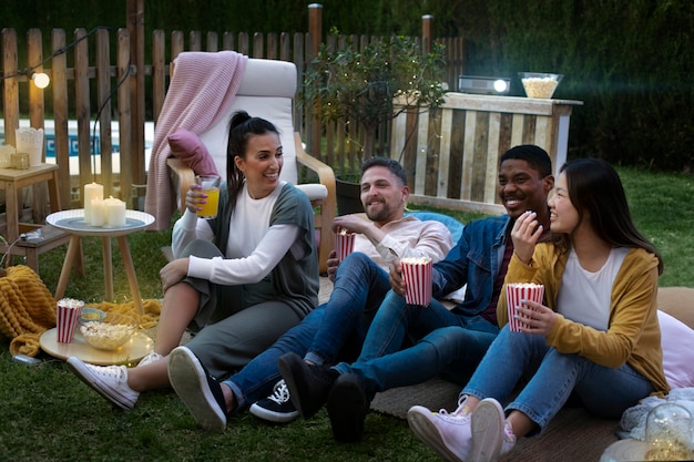 Free photo young friends having fun at cinema in open air