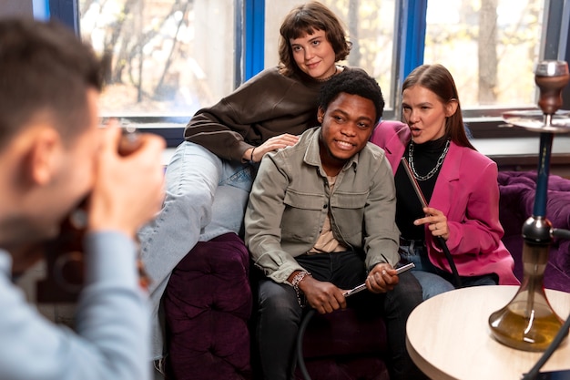 Young friends posing for a photo while enjoying a hookah