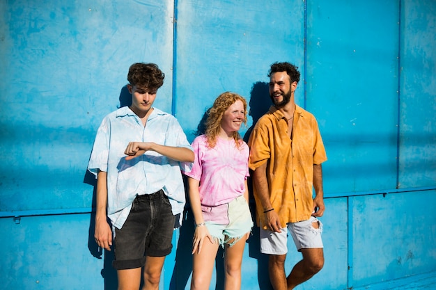 Free photo young friends posing with blue background