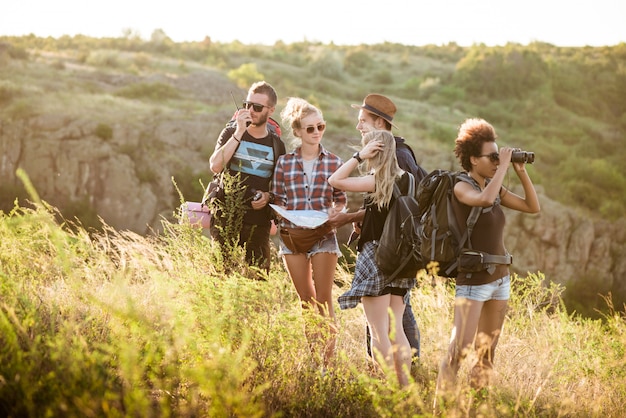 Young friends with backpacks enjoying view, traveling in canyon