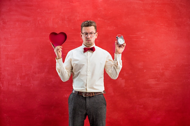 Free photo young funny man with abstract heart and clock