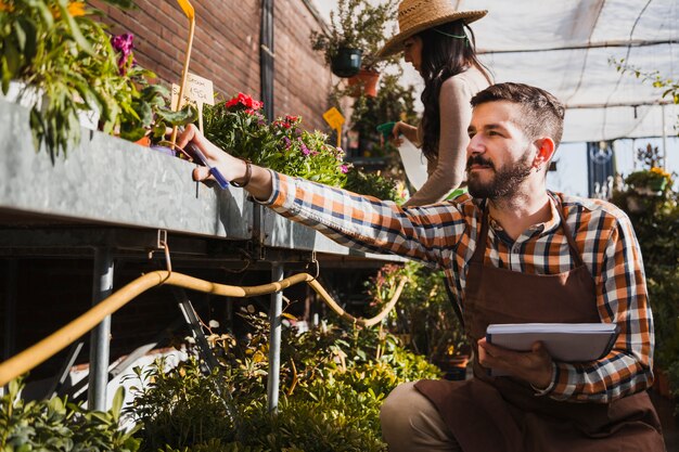 Young gardeners spraying plants and making notes