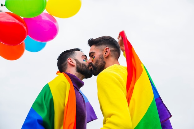 Free photo young gay couple kissing on parade