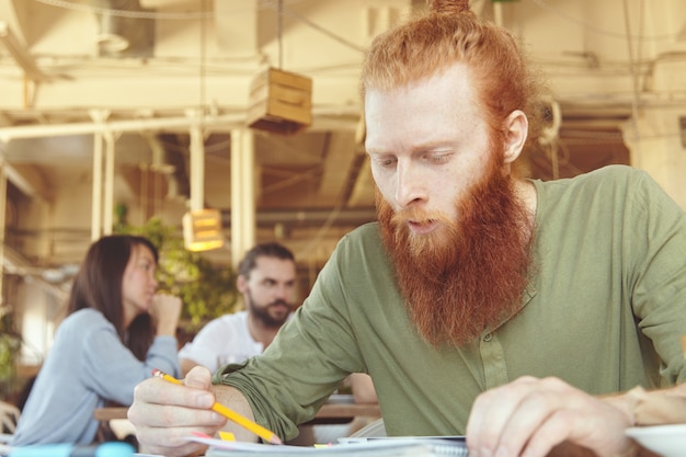 Free Photo young ginger man using tablet in cafe