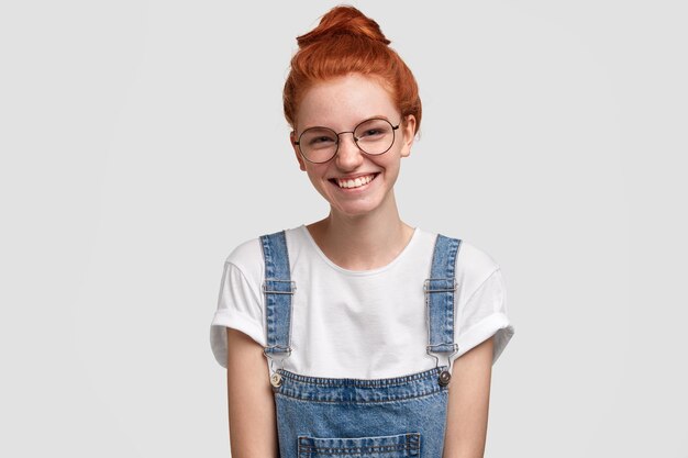 Young ginger woman wearing denim overalls