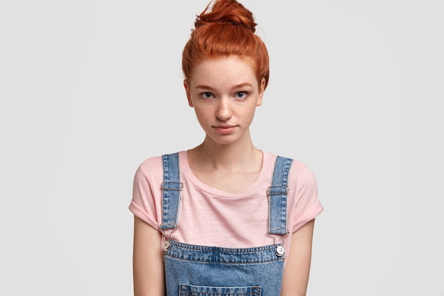 Young ginger woman wearing denim overalls