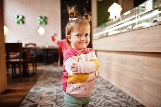 Free photo young girl in cafe choose a dessert from shop window