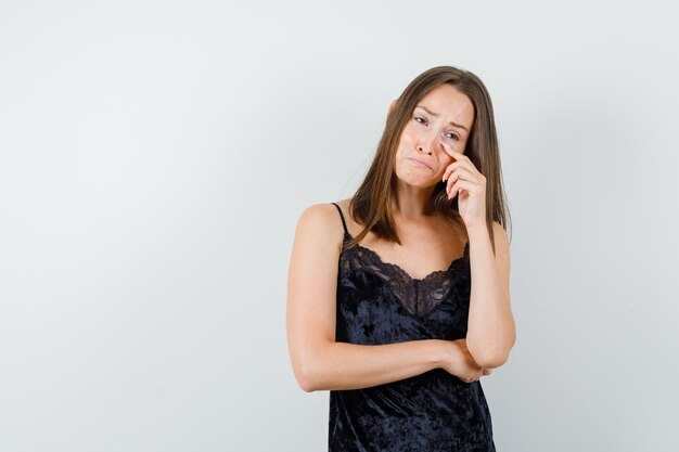 Young girl crying while looking away in black singlet and looking sorrowful