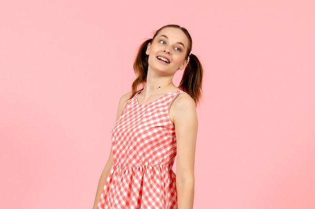 young girl in cute pink dress with smiling face on pink